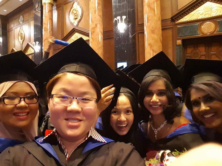 Malaysia graduates taking a group selfie with five smiling graduates