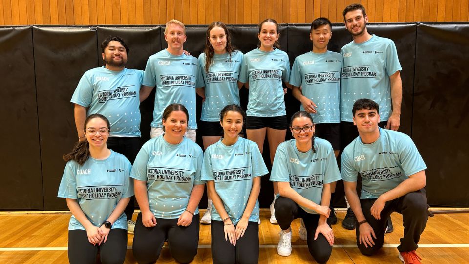 Two rows of five people standing on a basketball course wearing VU shirts. Front row is kneeling. All are smiling at camera.