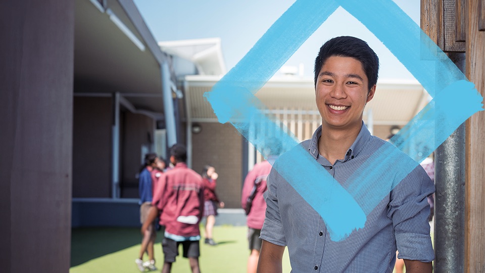 A man stands in a schoolyard with the VU blue branded logo