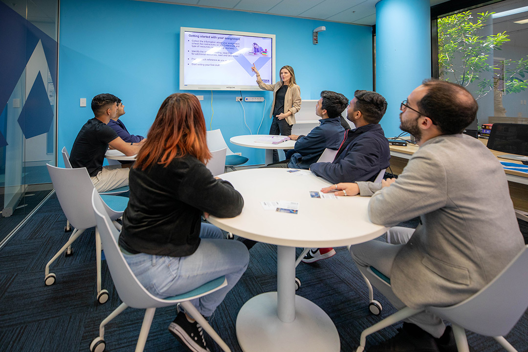 A group of 5 students watch a presentation