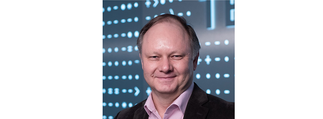 Man in professional dress in front of a digital backdrop