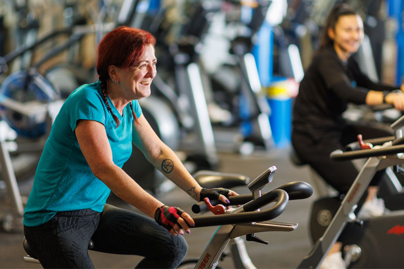 Two women cycle on the exercise bikes at Footscray Park Fitness Centre