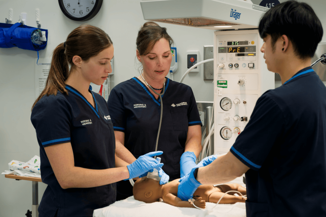 A group of midwifery students practising resuscitation on a manikin baby