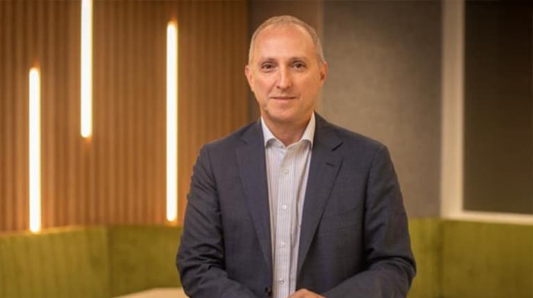 Senior Deputy Vice-Chancellor and Chief Academic Officer John Germov standing indoors and smiling at the camera