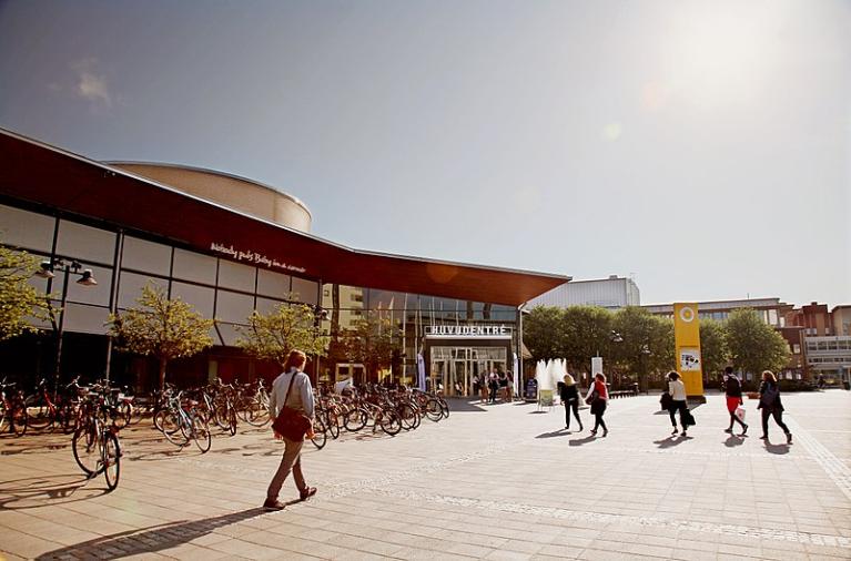 Students walking across an open space with a Karlstad University building in the background