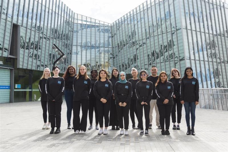 A group of Student Mentors stand together in the courtyard outside M building on VU's Footscray Park campus.