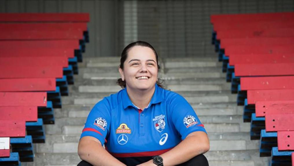 Brooke Muscat in Western Bulldogs uniform sitting on steps in a stadium