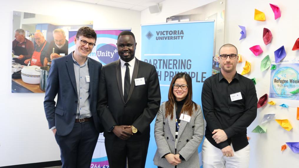 Four people standing in front of a VU and commUnity+ sign - smiling at camera.