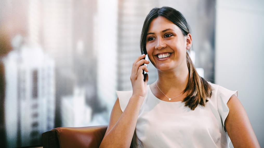 Young woman on the phone in a city office, in professional clothing