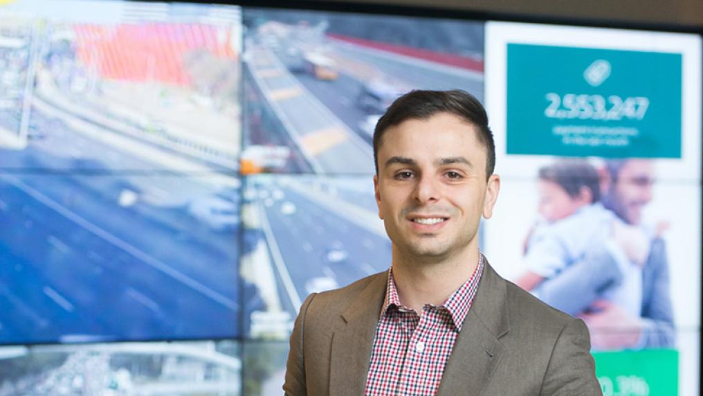 Student stands in front of screens.