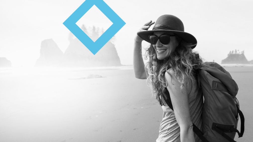 A woman in a hat explores the Great Ocean Road. The blue VU diamond sits next to her.