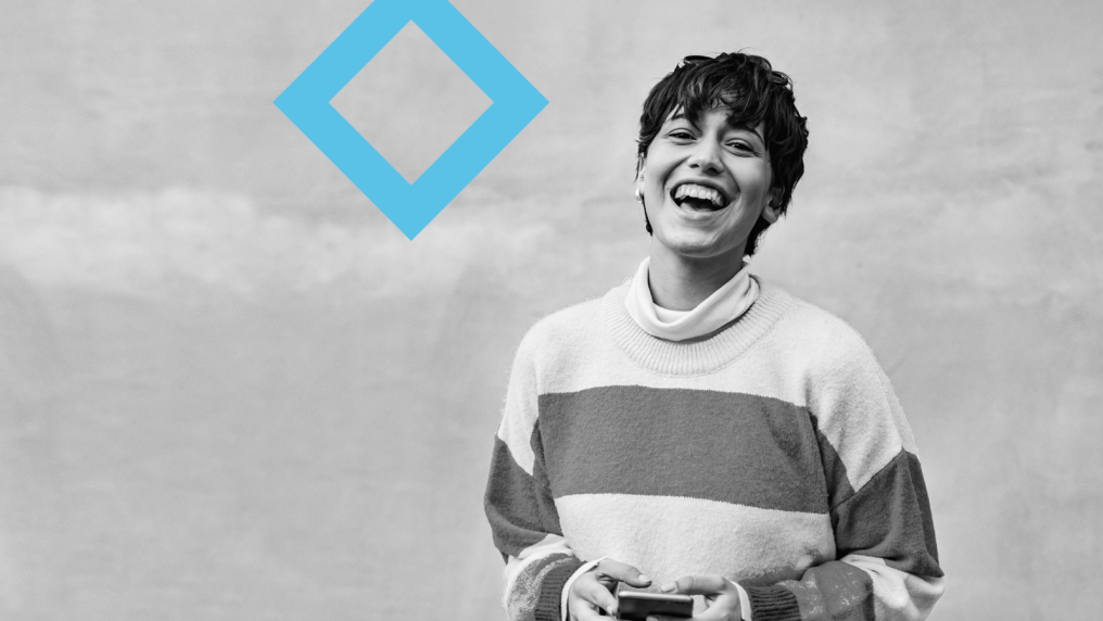 A laughing student stands next to the VU blue branded diamond.