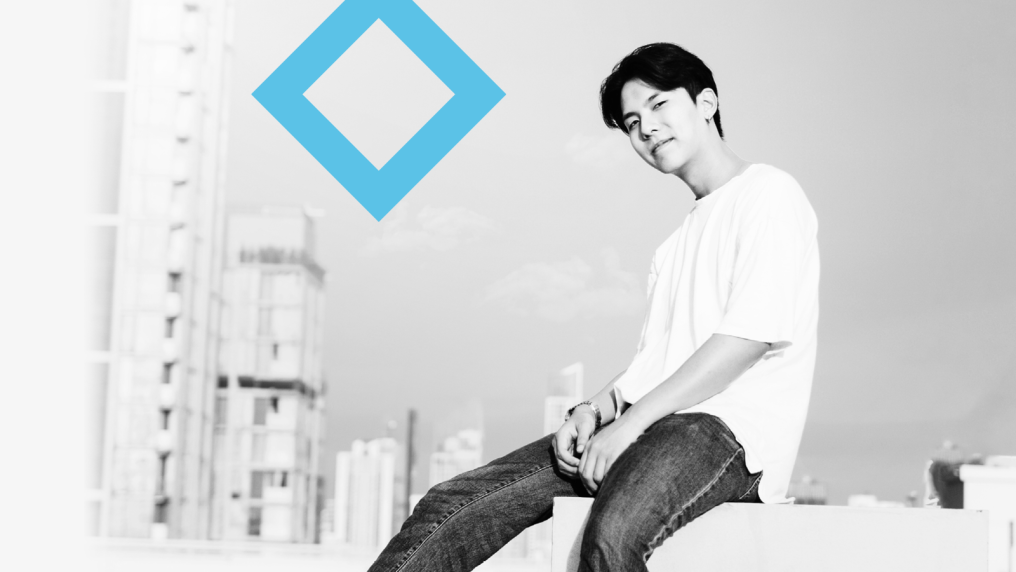 A student sits next to the VU blue branded diamond.