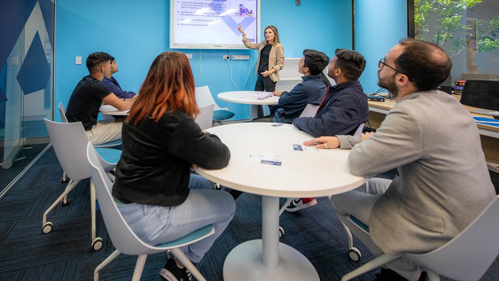 A group of 5 students watch a presentation