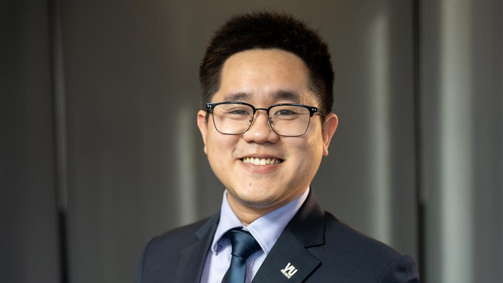 A young man in a suit poses for the camera