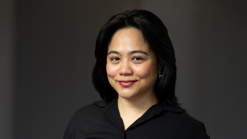 A woman poses for a photo in a neat black shirt