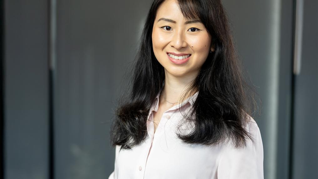 A young woman smiles for the camera in a neat white shirt