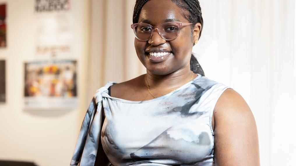 A young woman smiles for the camera in an elegant dress
