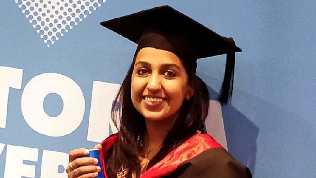 Alia Asif smiling in graduation cap and gown