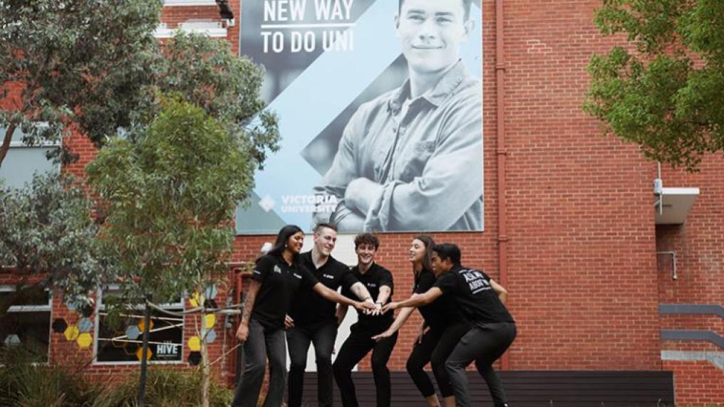 Student ambassadors in front of a VU billboard