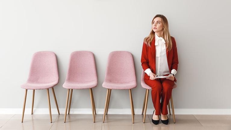 A woman sits, waiting to be interviewed for a job